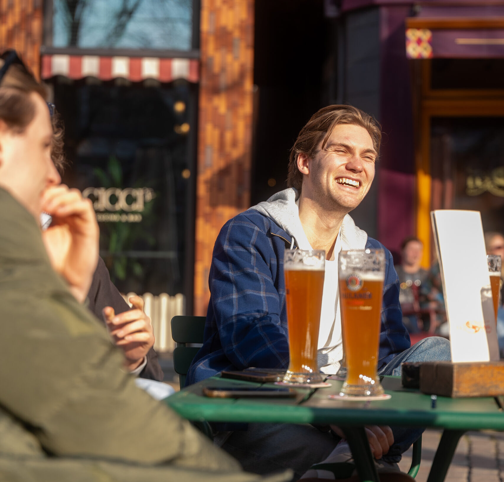 Collega's die samen borrelen op het terras aan de Hoge der A